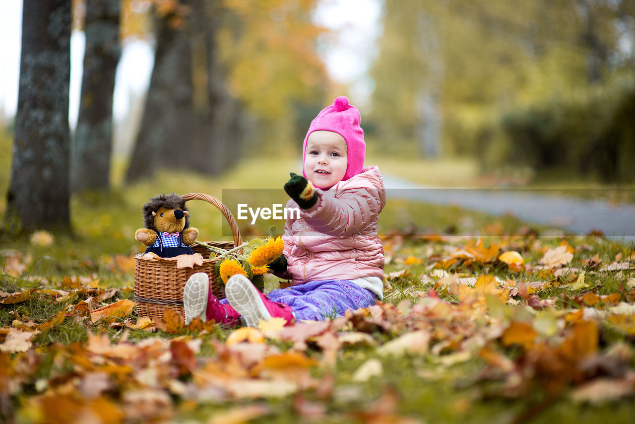 Cute baby girl sitting on field at park