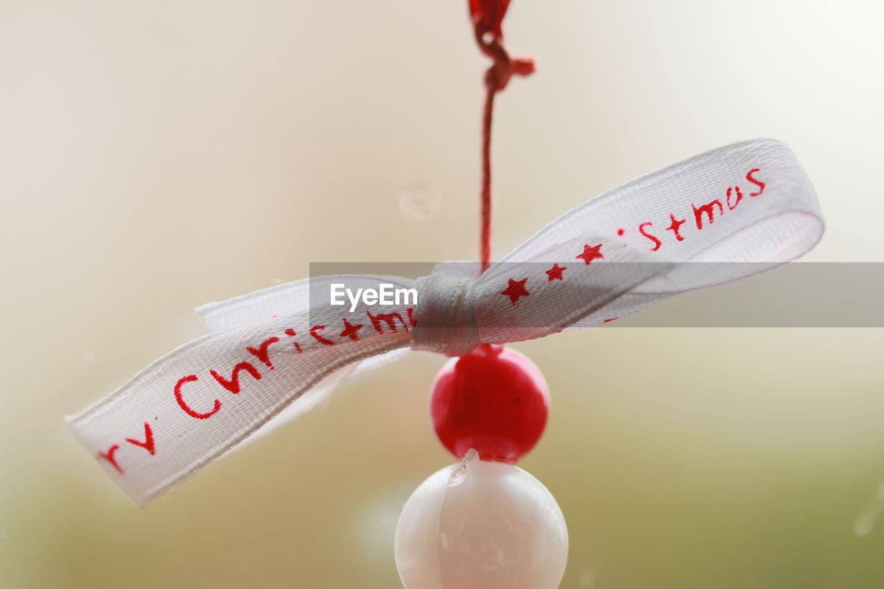 Close-up of love hanging over white background
