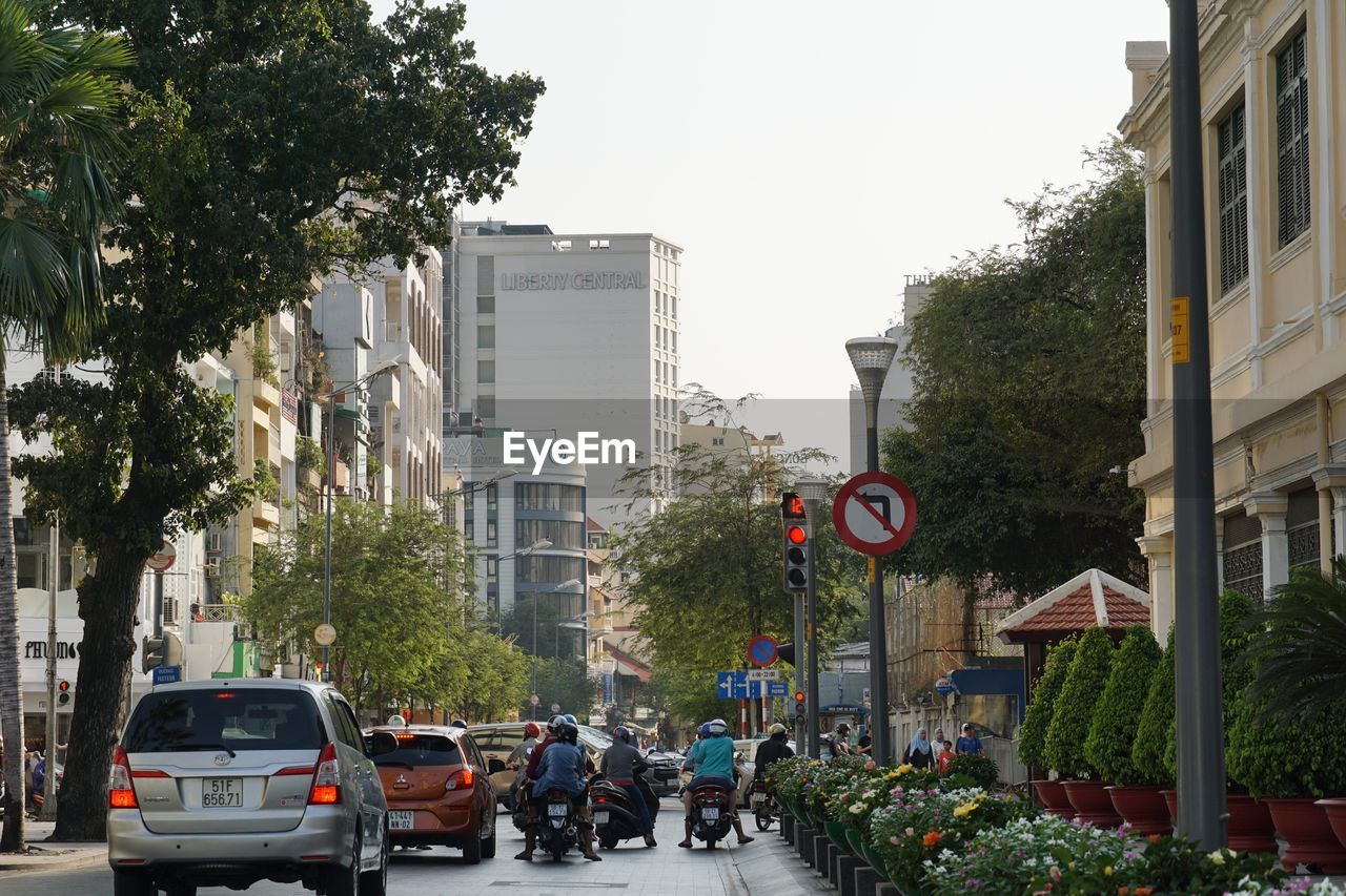 CARS ON CITY STREET AMIDST BUILDINGS