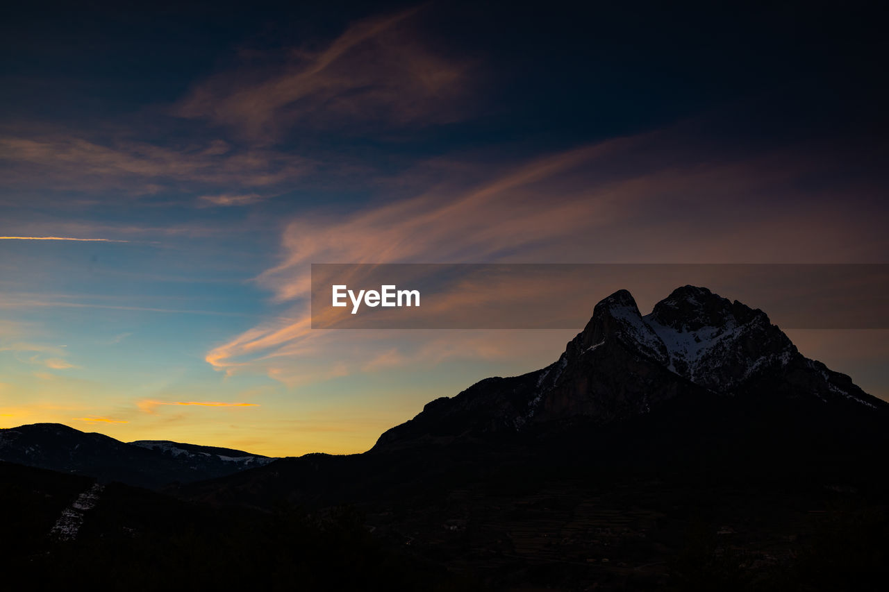 SCENIC VIEW OF MOUNTAINS AGAINST SKY AT SUNSET