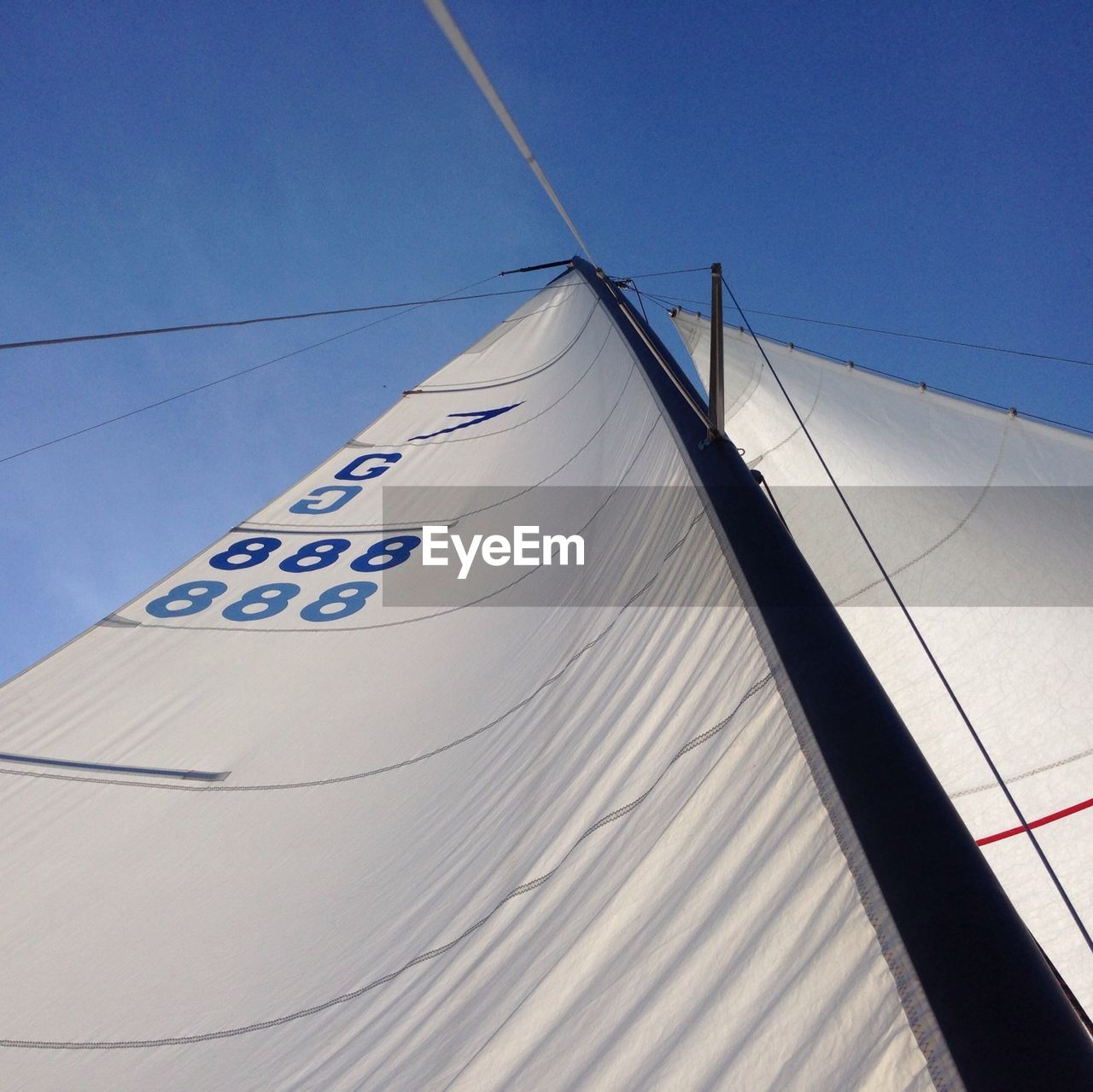 Low angle view of sailboat canvas against clear blue sky