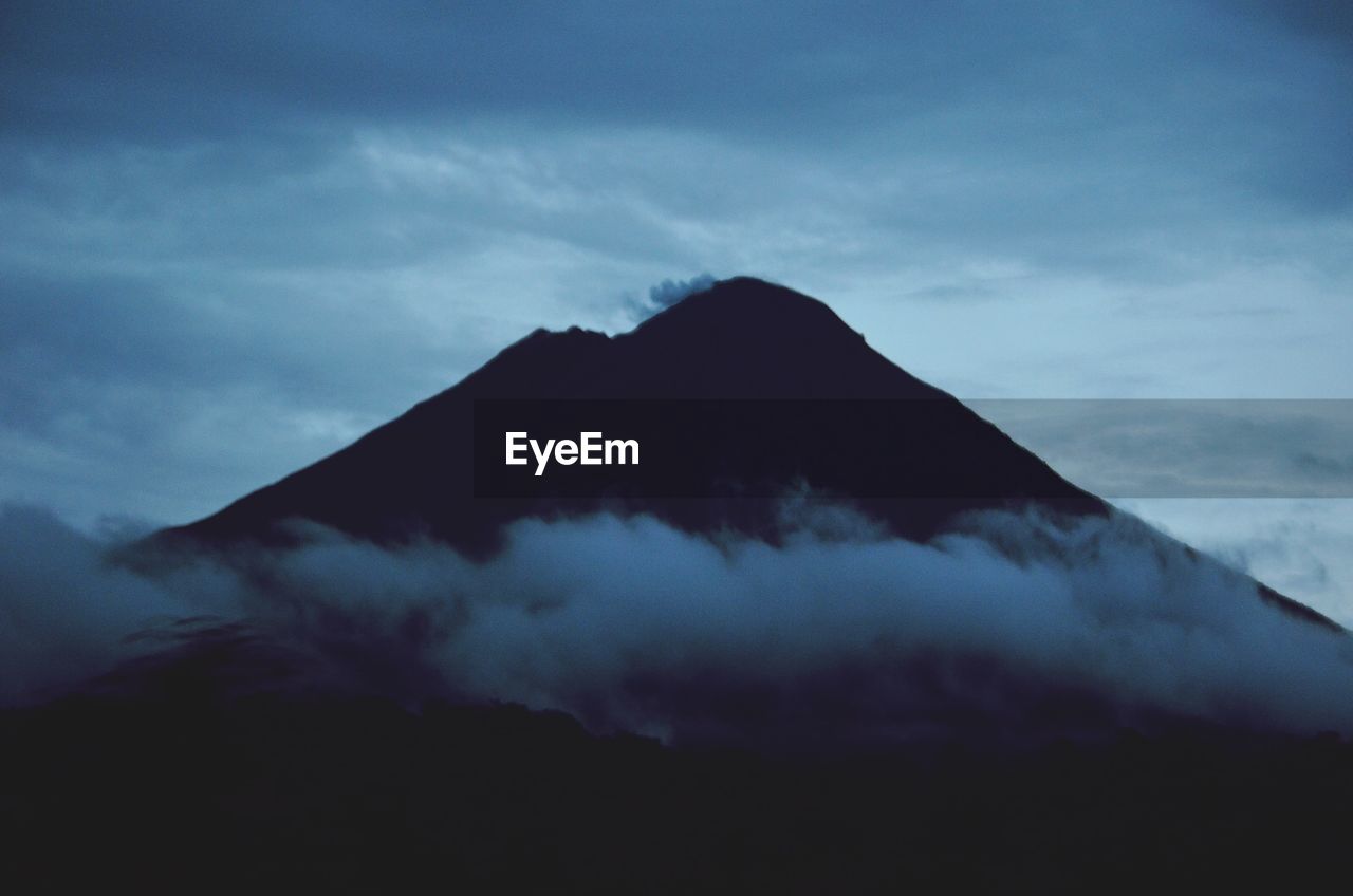 Majestic arenal volcano against cloudy sky at dusk