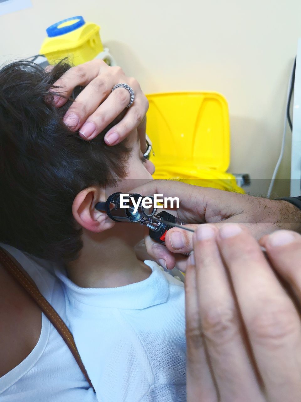 Cropped hands doctor checking ear of patient