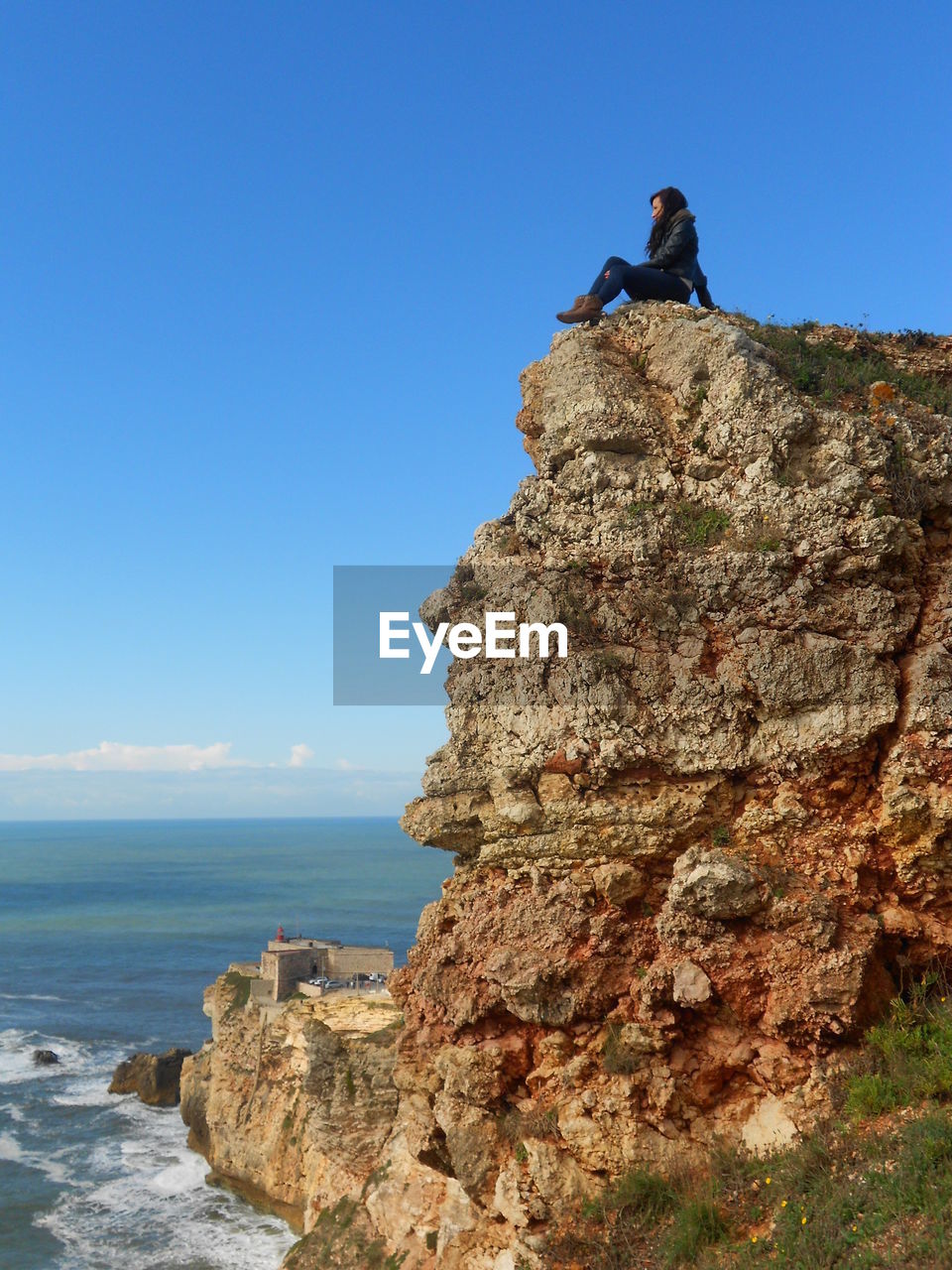 Person on rock against sky