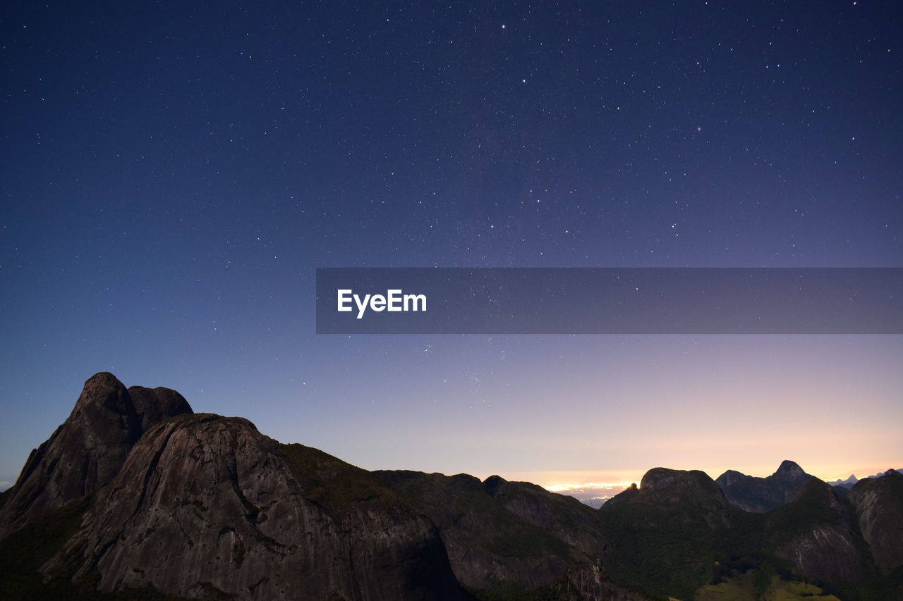 Scenic view of mountains against sky at night