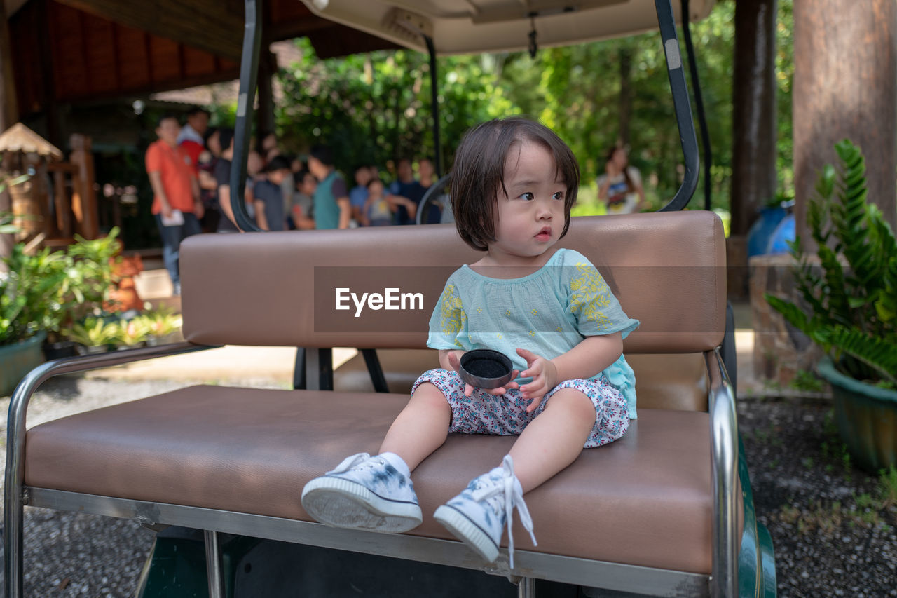 Portrait of cute girl sitting on golf cart