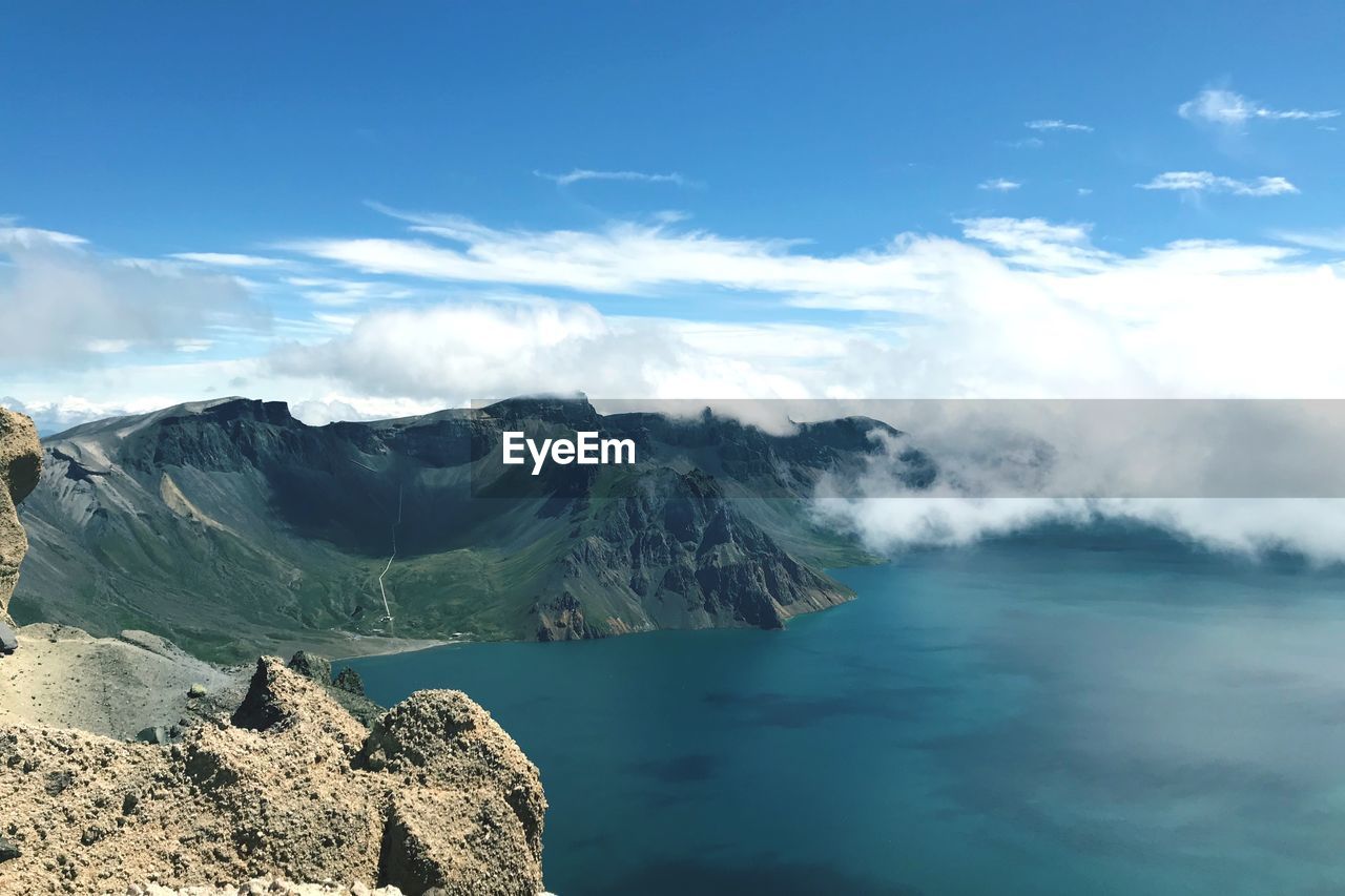 Scenic view of sea and mountains against sky