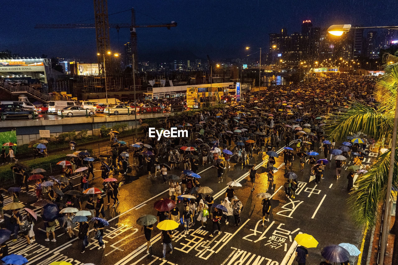 High angle view of people on city street at night during rainy season
