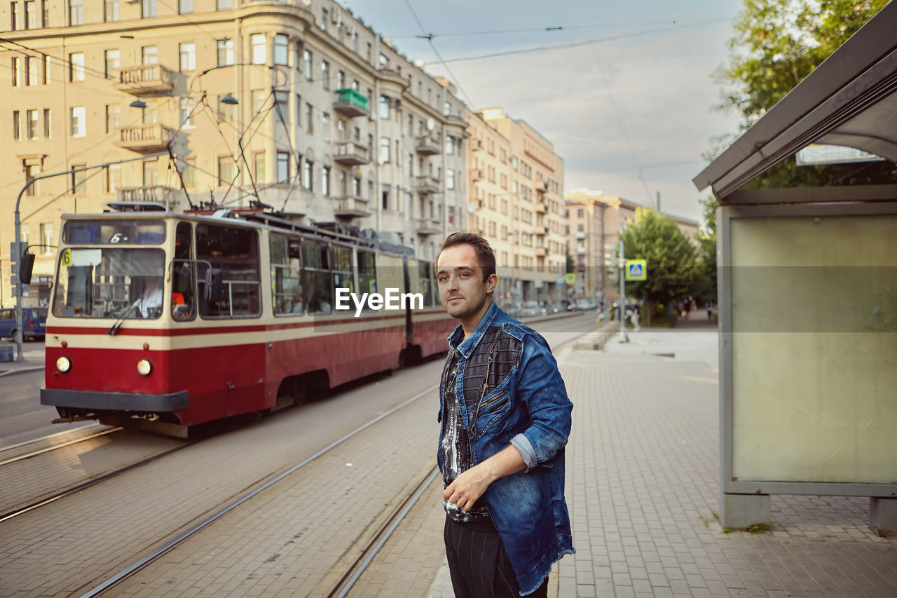 Young man standing on street in city