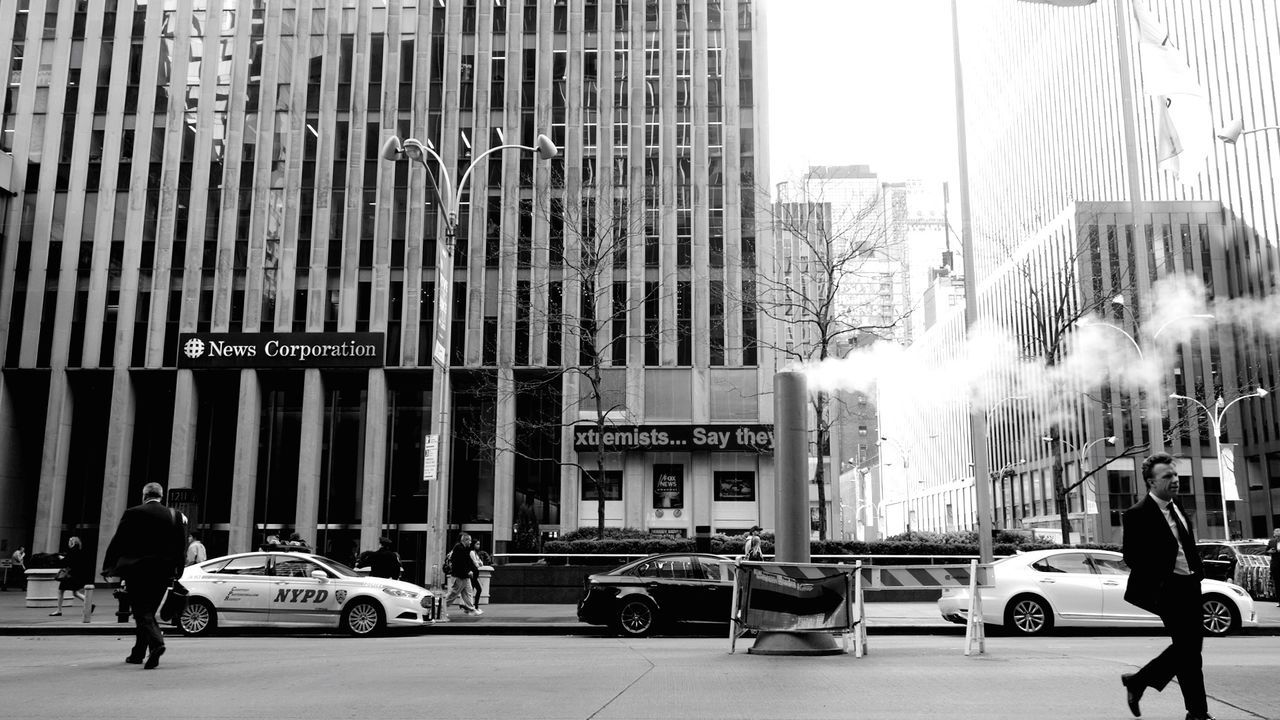 PEOPLE WALKING ON ROAD IN CITY