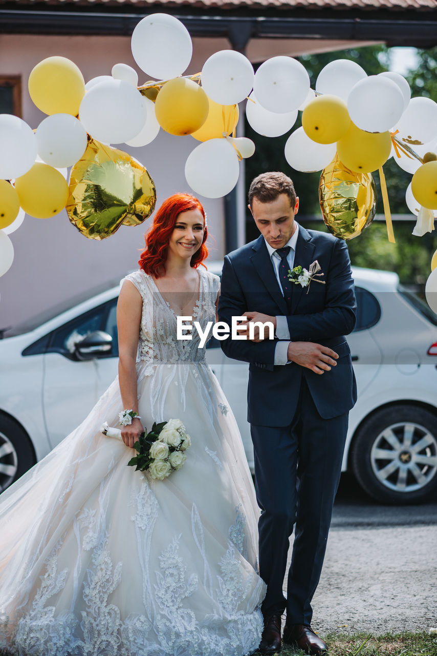 Full length of couple holding bouquet