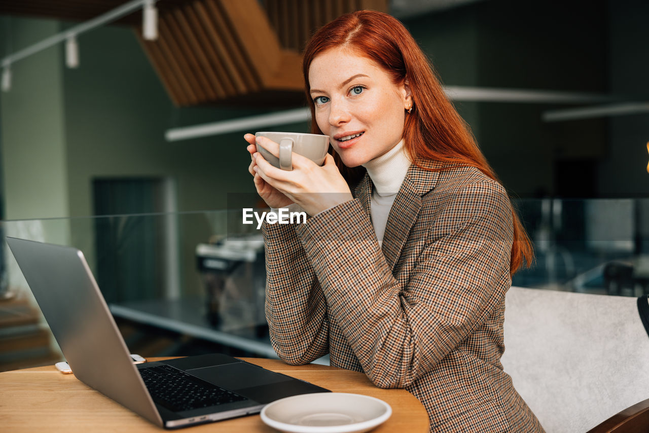 young woman using mobile phone while sitting at office