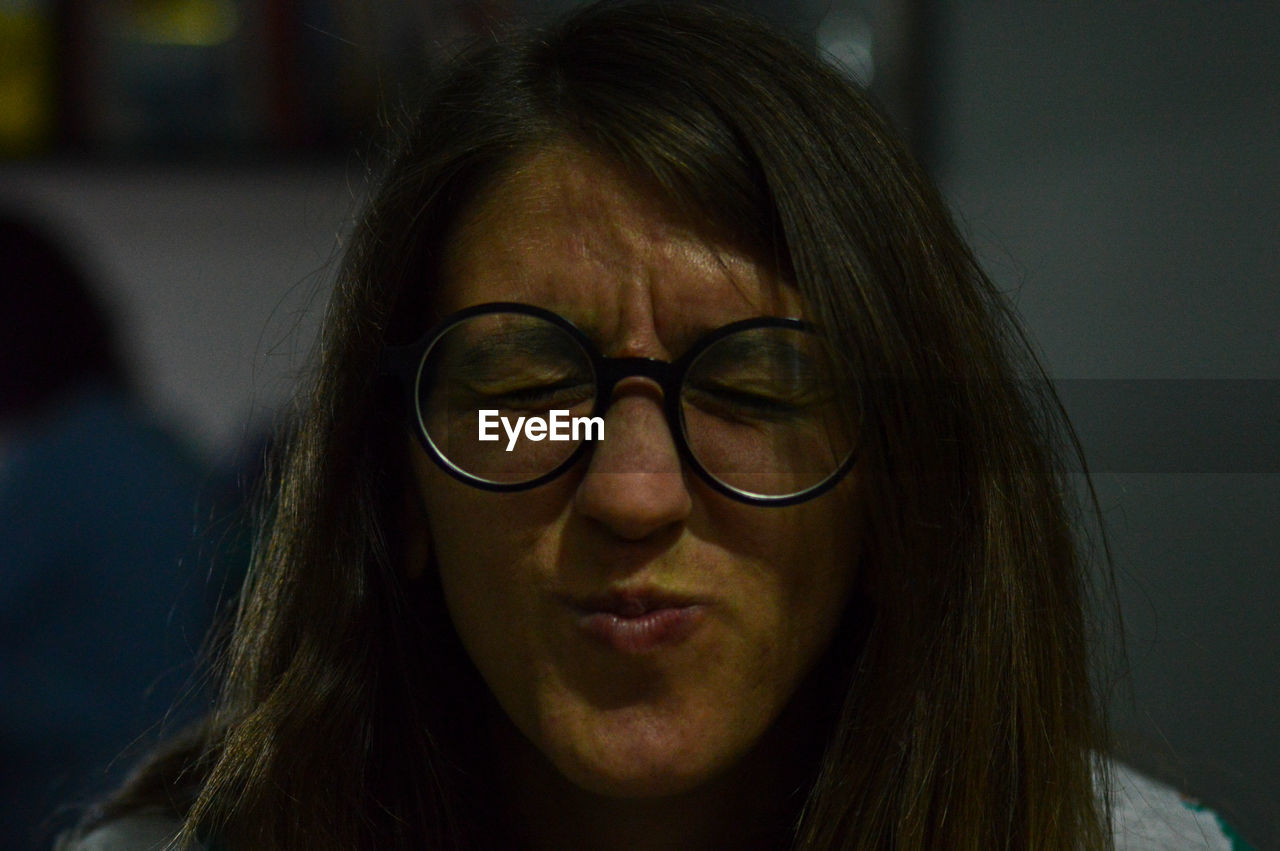 Close-up of woman wearing eyeglasses making face