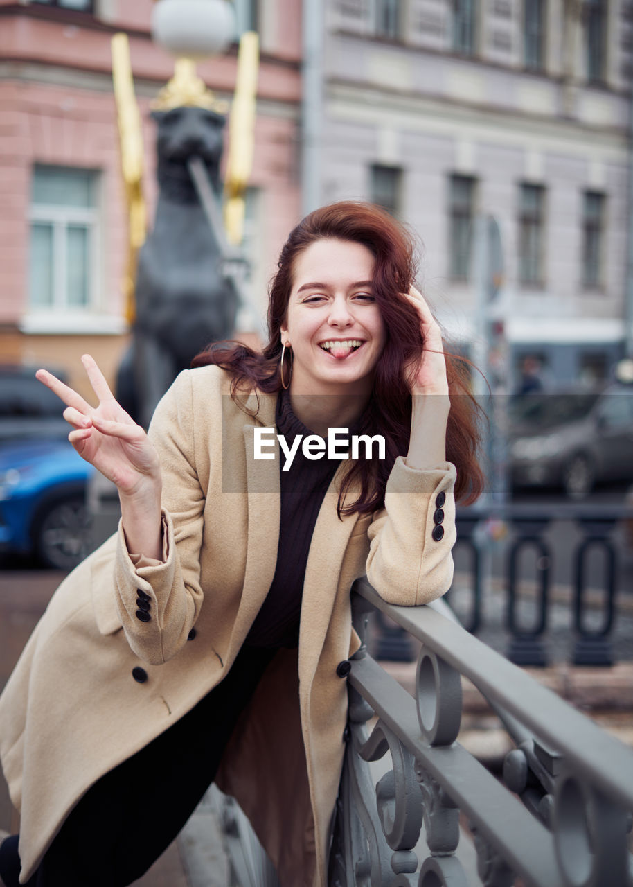 Portrait of smiling young woman on bridge in city