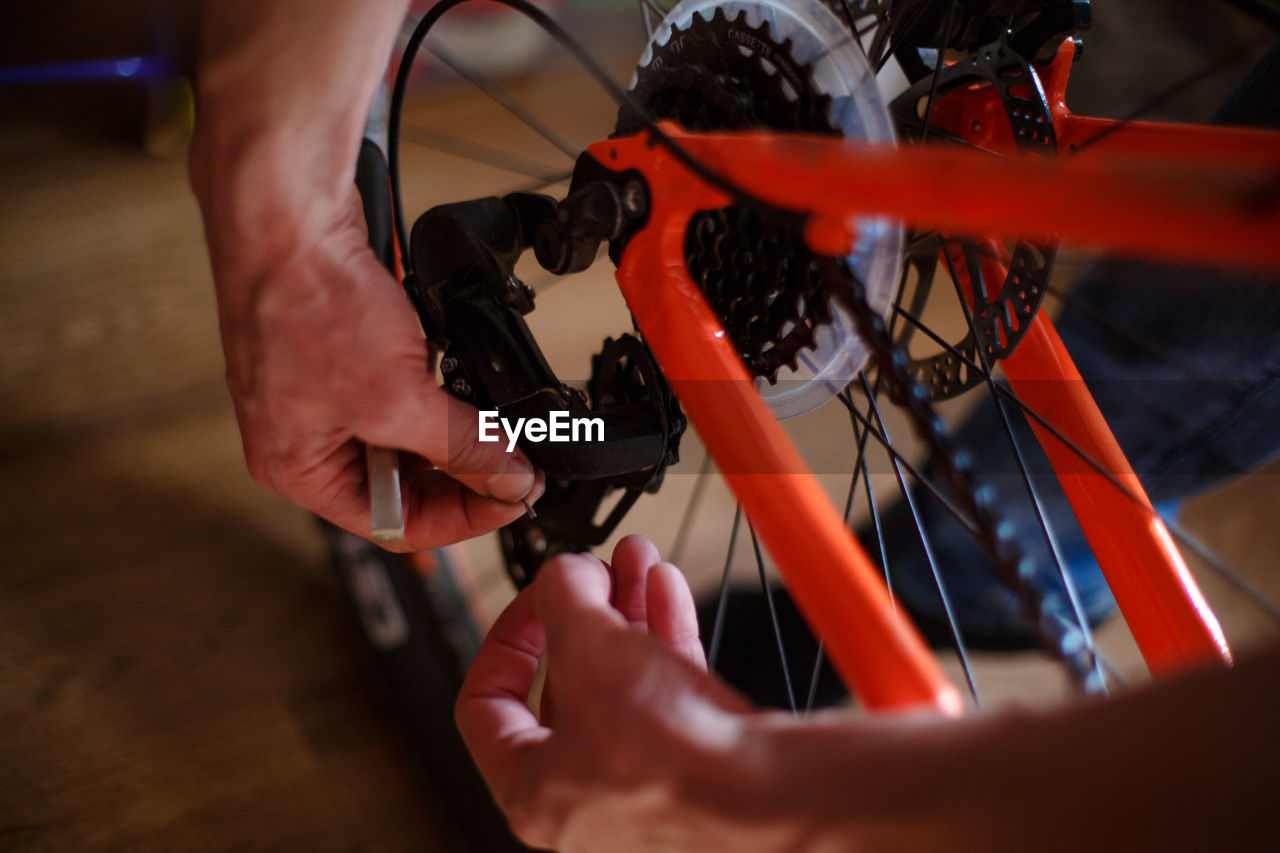 Hand of a man with a multitool near the wheel and brakes of the bike. bike repair, setting up disc 