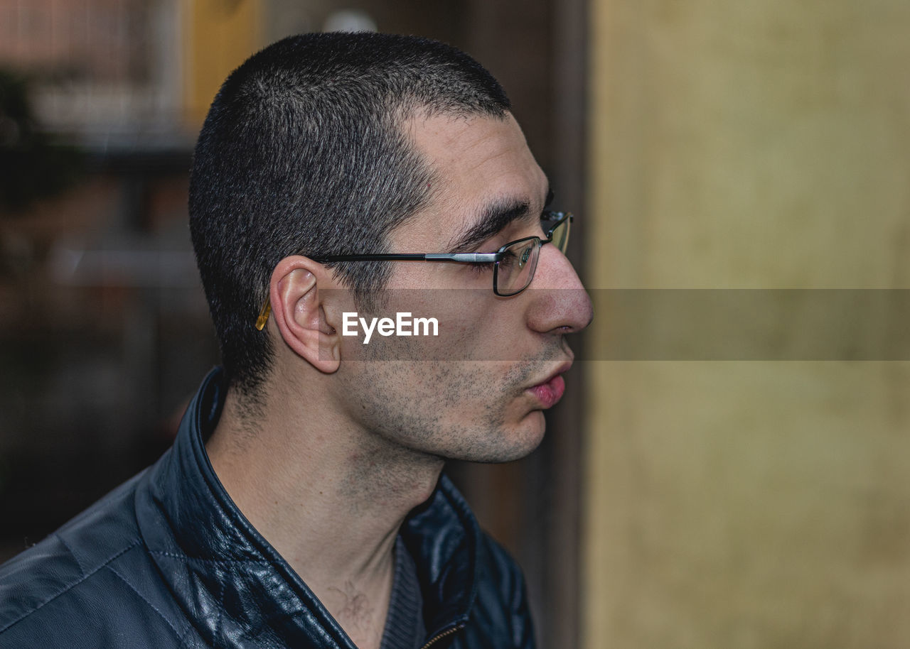 CLOSE-UP PORTRAIT OF YOUNG MAN WITH EYEGLASSES