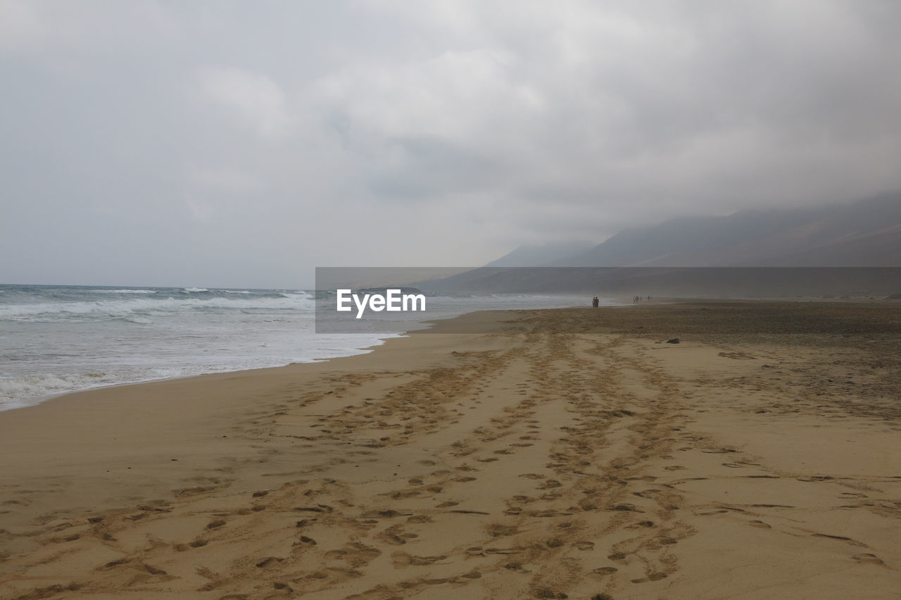 SCENIC VIEW OF SANDY BEACH AGAINST SKY