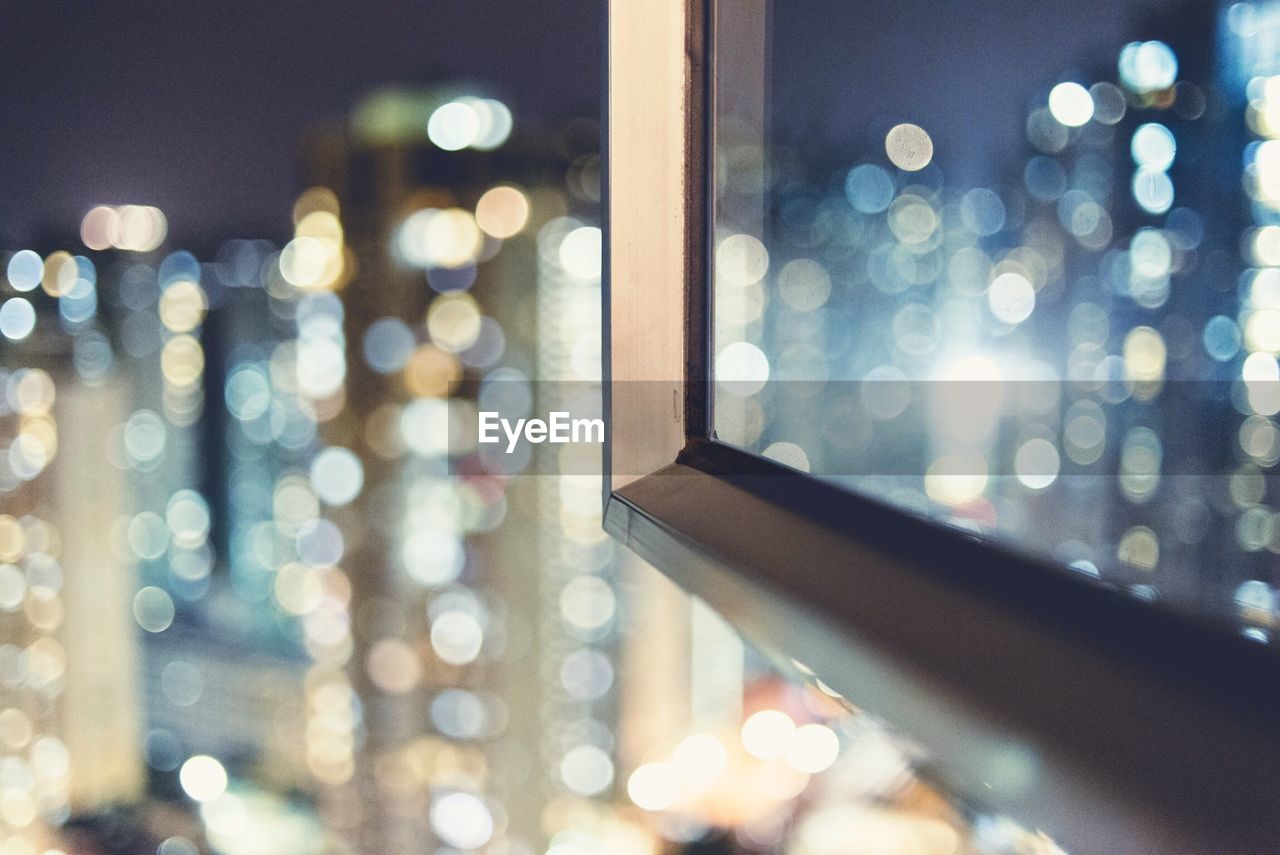 Defocused image of cityscape seen through window