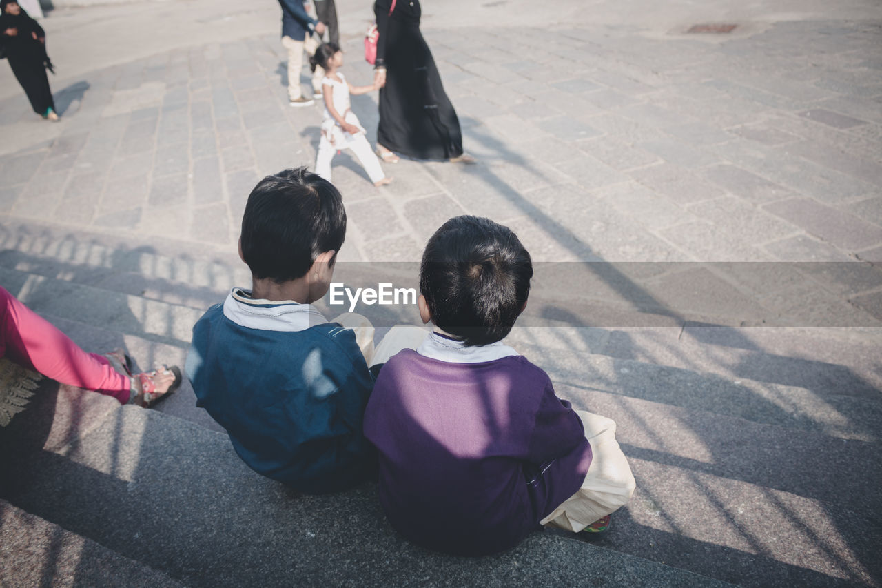 High angle view of boys sitting on street