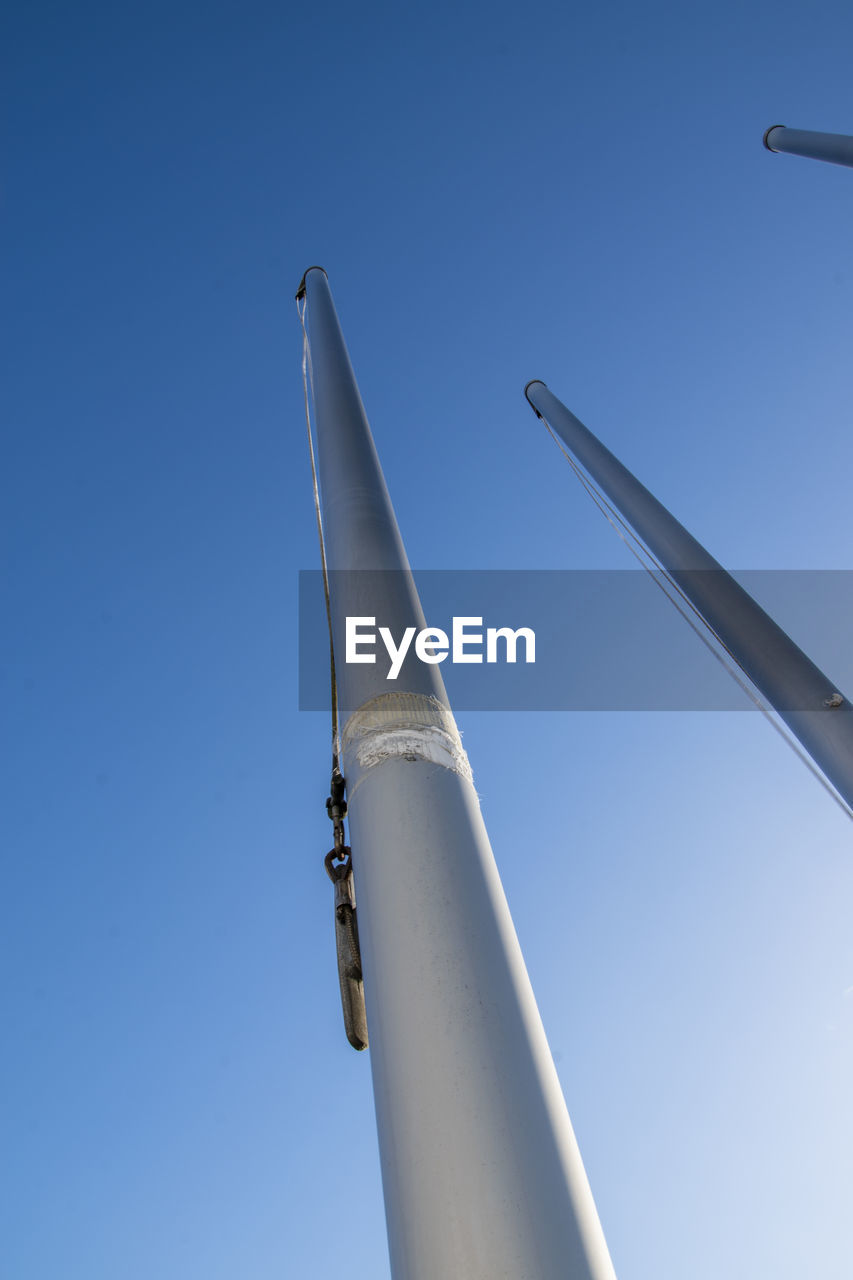 Flagpoles on a cold sunny winter day against a blue clear sky