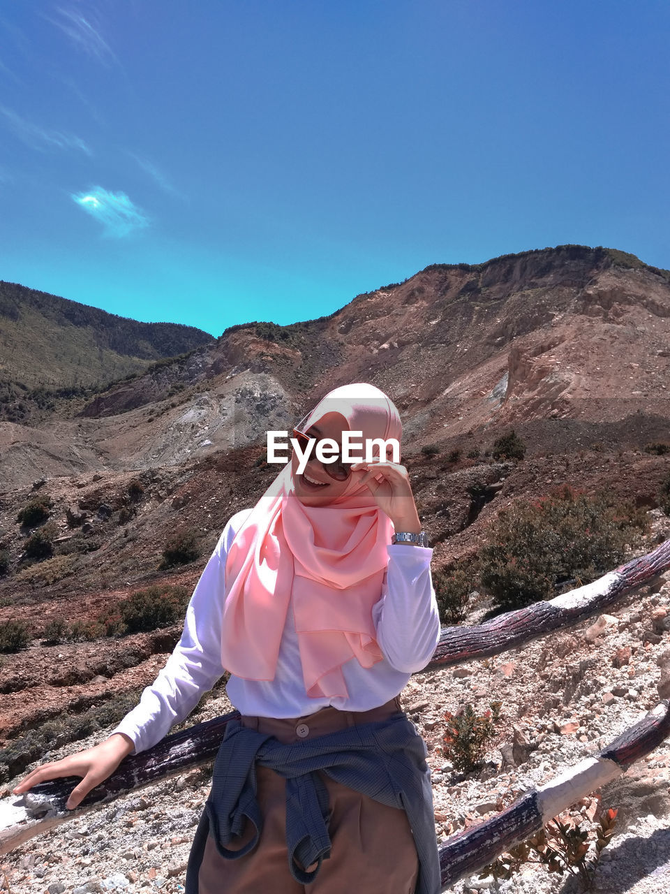 Portrait of woman in hijab standing against mountain