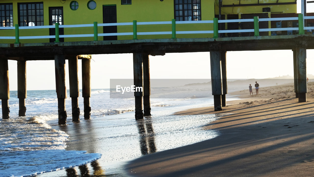 Pier on beach against sky
