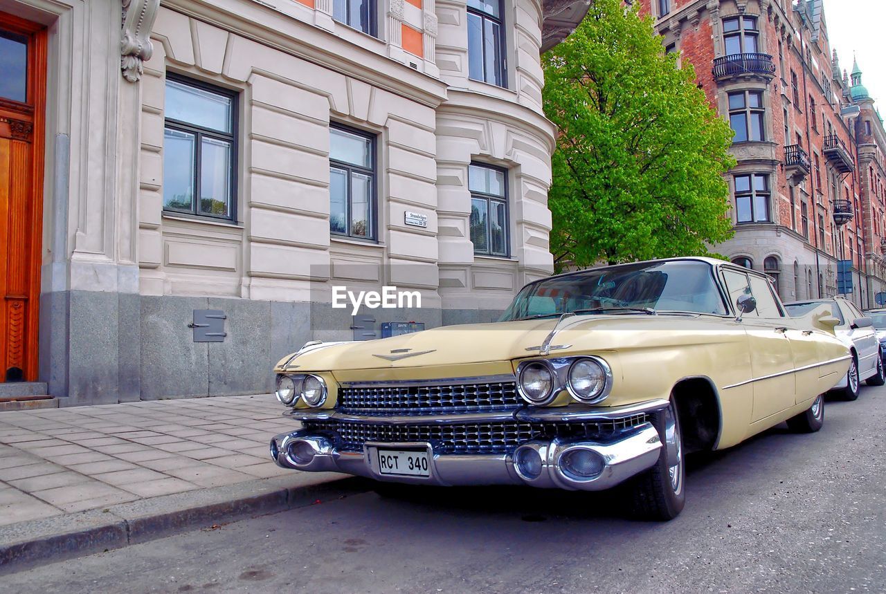 VINTAGE CAR ON STREET AGAINST BUILDING