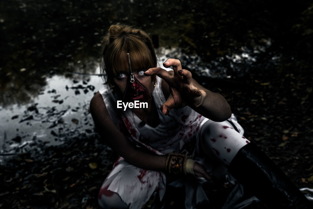 Portrait of woman wearing spooky make-up at night