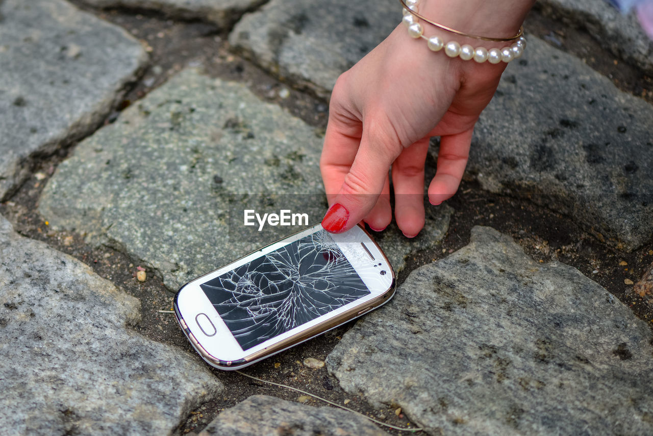 CLOSE-UP OF HAND HOLDING ROCK