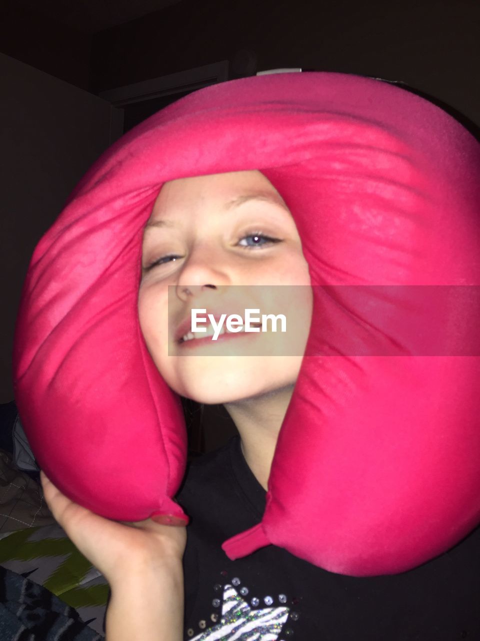 Close-up portrait of girl with pink neck pillow