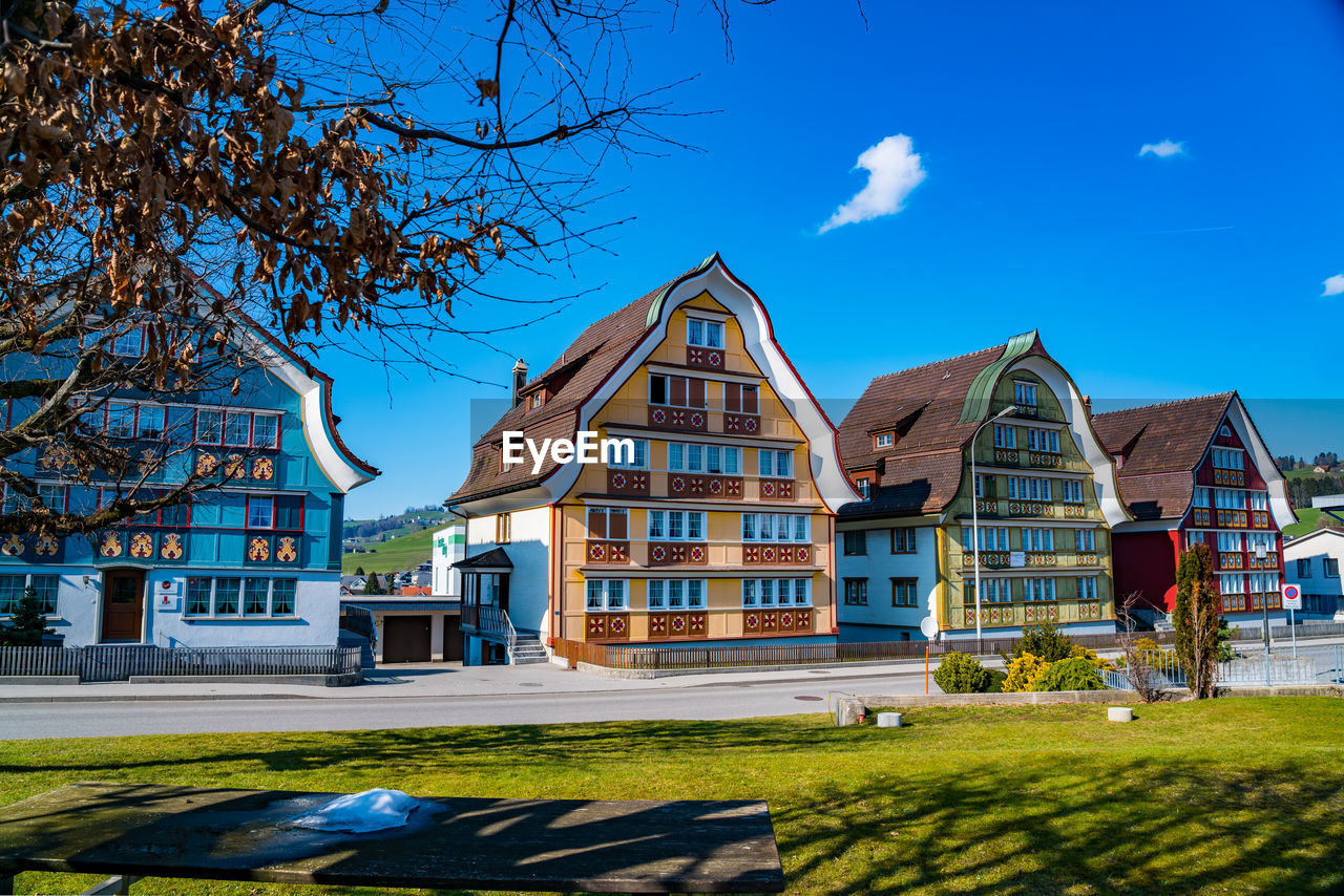 Lawn by building against blue sky