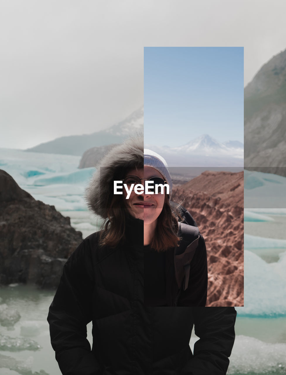 PORTRAIT OF SMILING YOUNG WOMAN STANDING ON MOUNTAIN