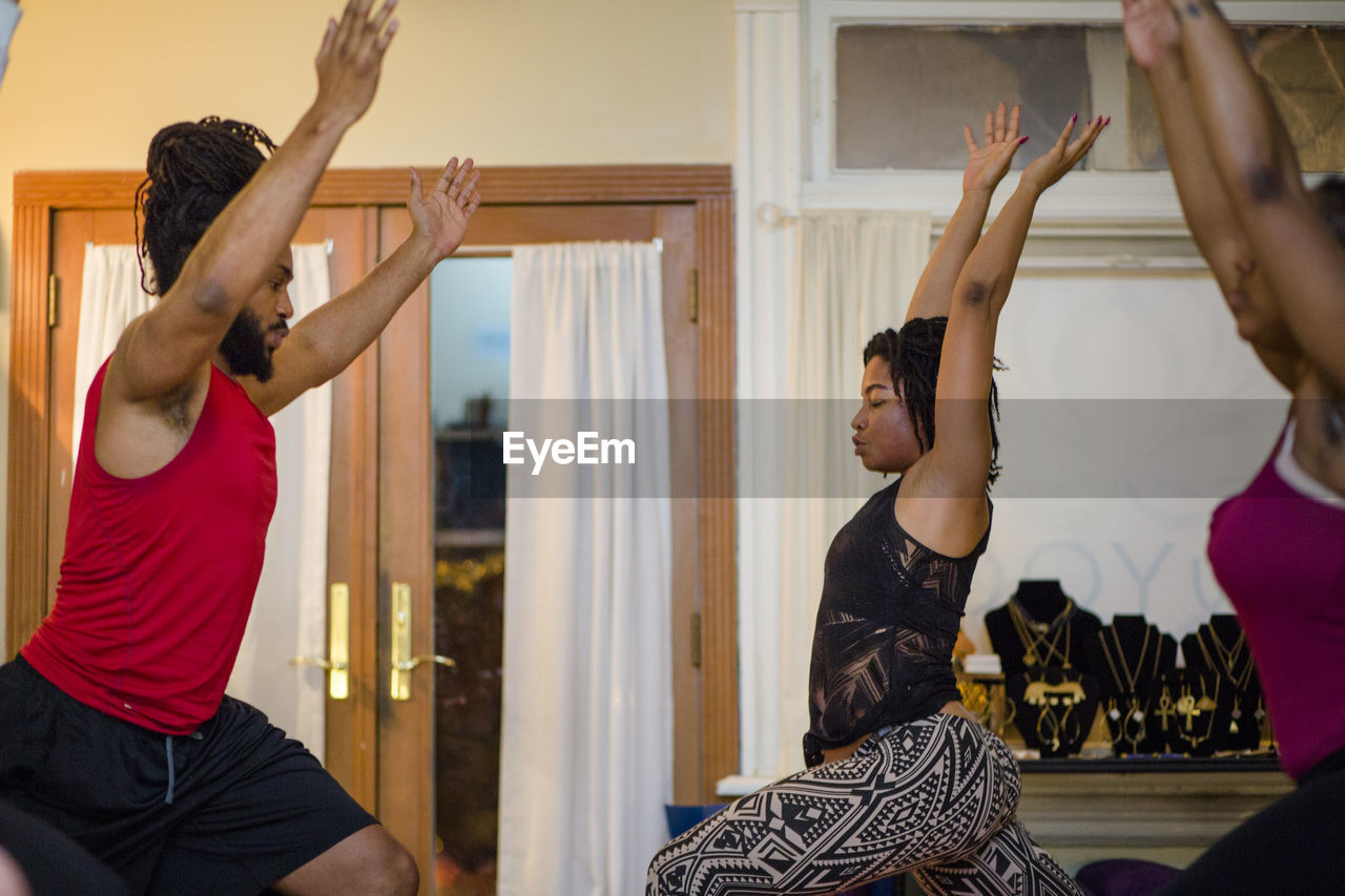 A female yoga instructor leads students in relaxation techniques