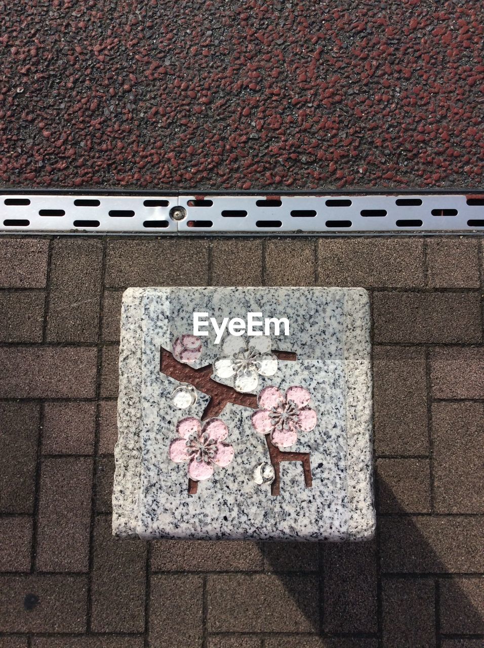 High angle view of floral pattern on stone at street