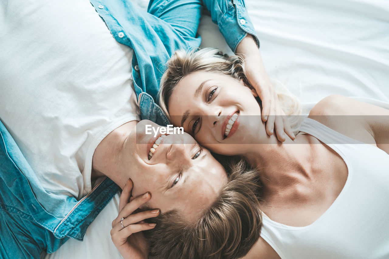 High angle portrait of couple lying on bed