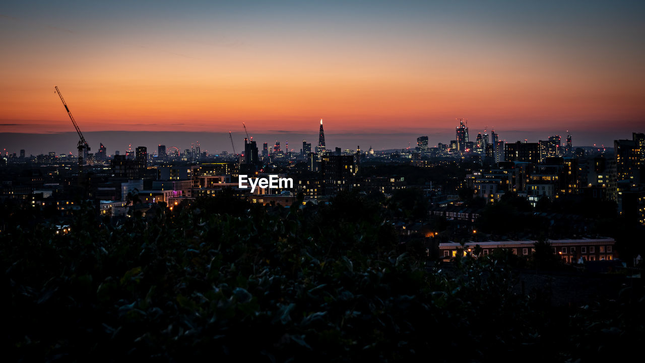 Silhouette buildings against sky during sunset