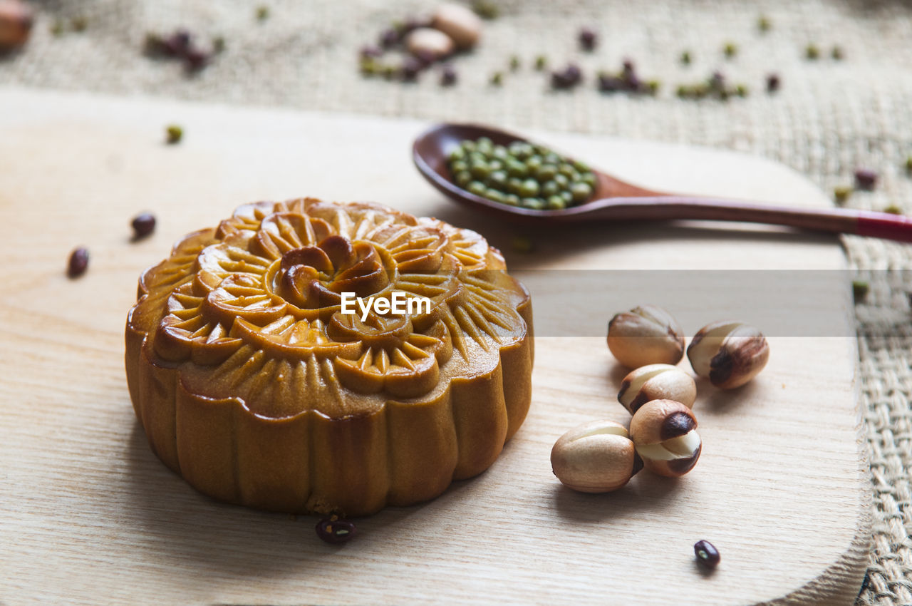 High angle close-up of moon cake with seeds on cutting board