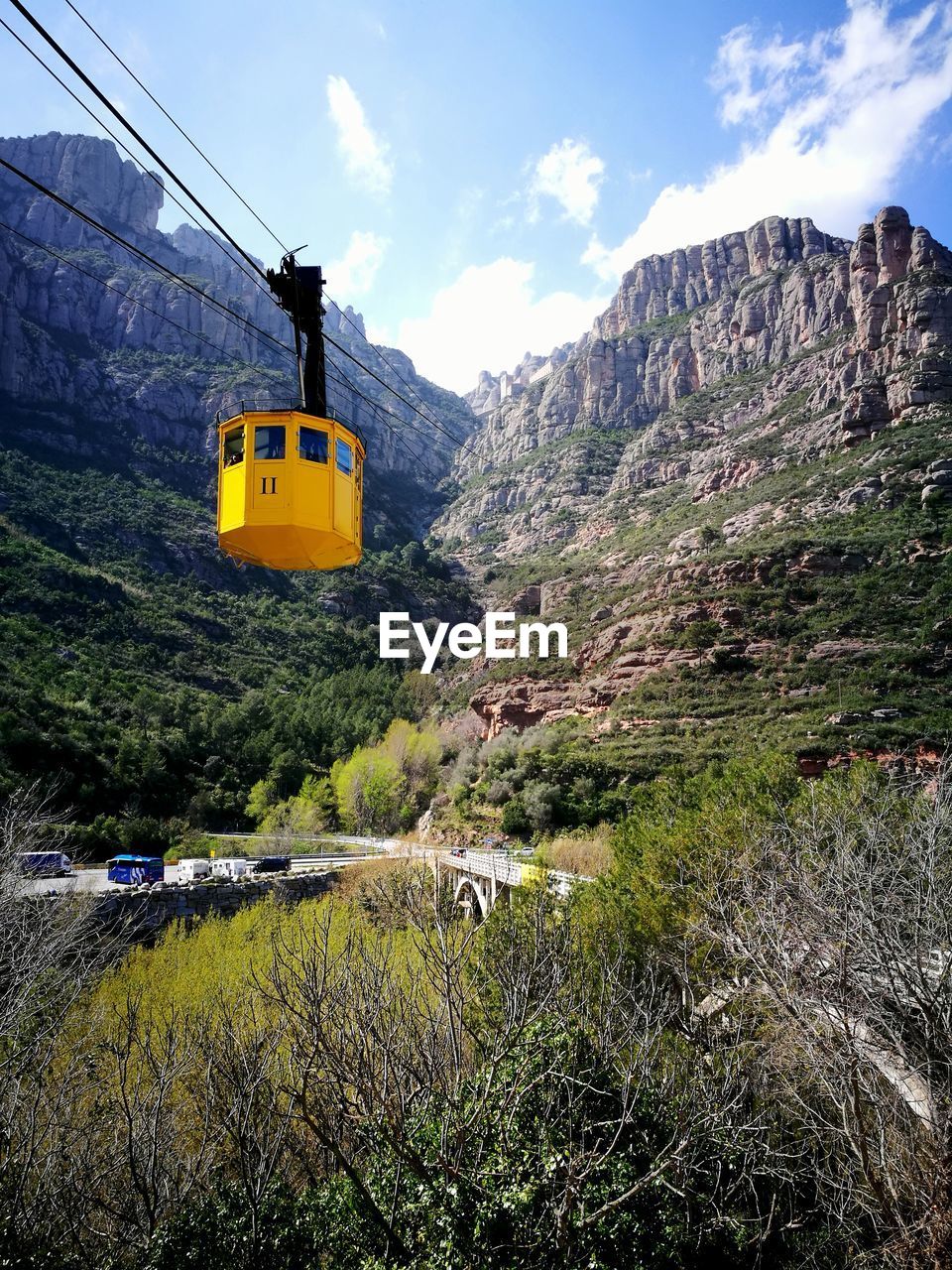 OVERHEAD CABLE CARS ON ROAD AGAINST SKY