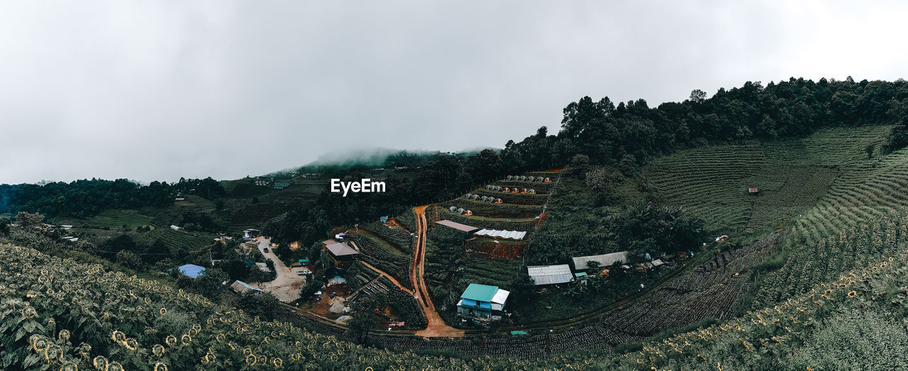 PANORAMIC SHOT OF BUILDING AND MOUNTAIN RANGE AGAINST SKY