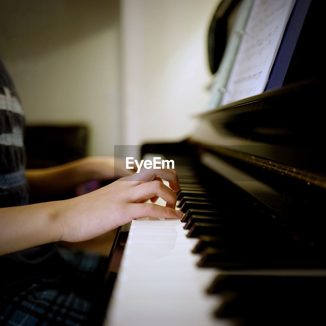 Midsection of man playing grand piano