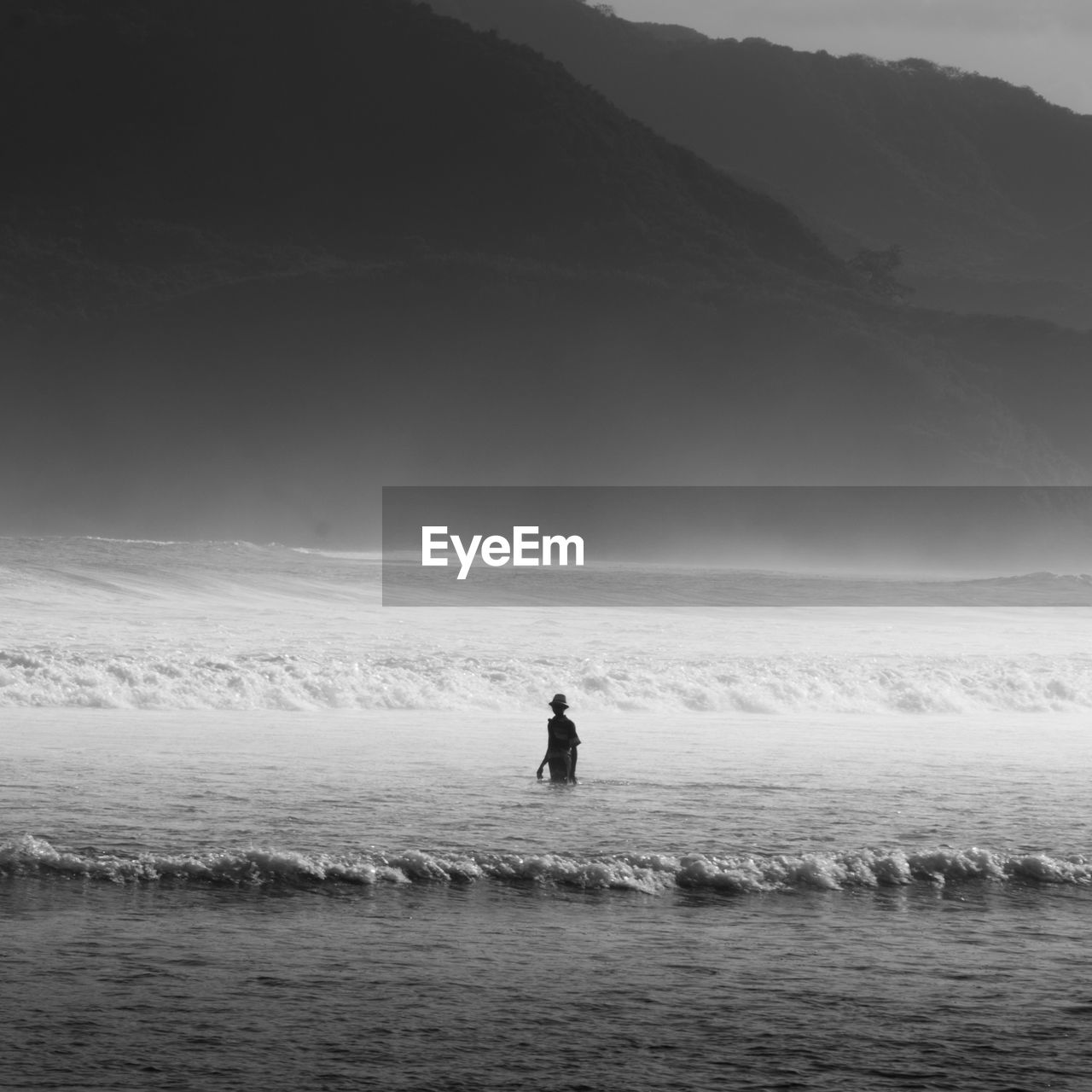 Man in sea against sky