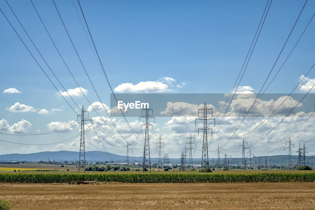 ELECTRICITY PYLONS ON LAND AGAINST SKY