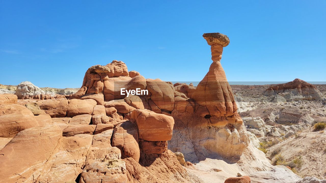 Low angle view of rock formations against clear blue sky