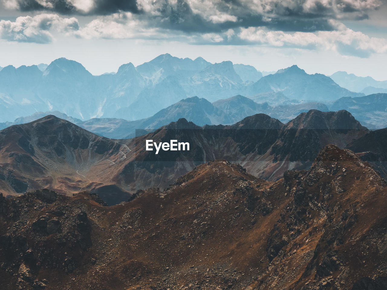 Scenic view of mountains against cloudy sky