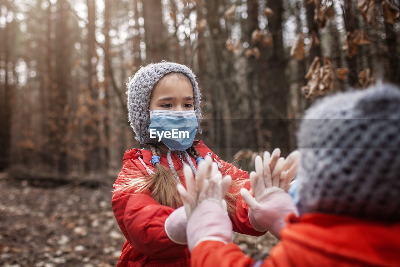 Cute kids wearing mask playing outdoors