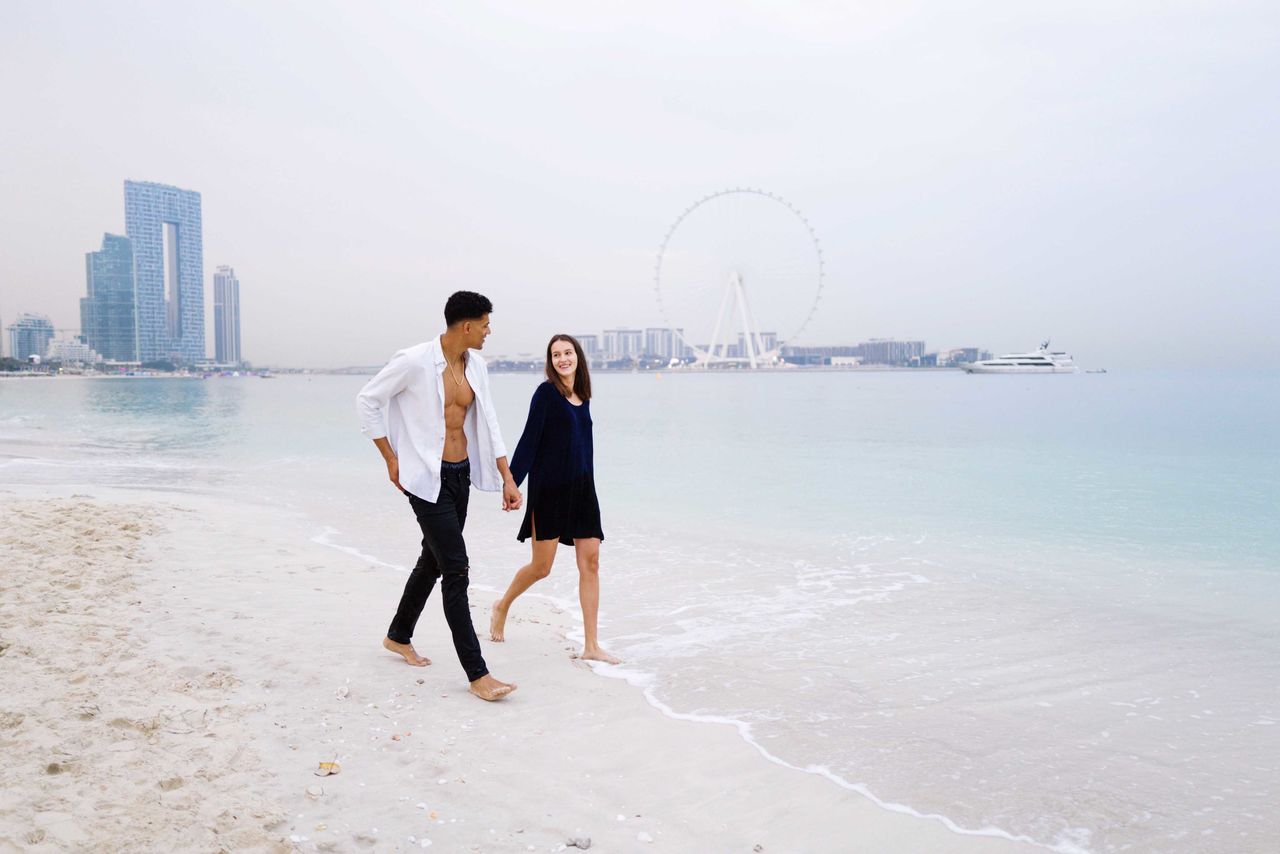 Full length of young couple walking at the beach