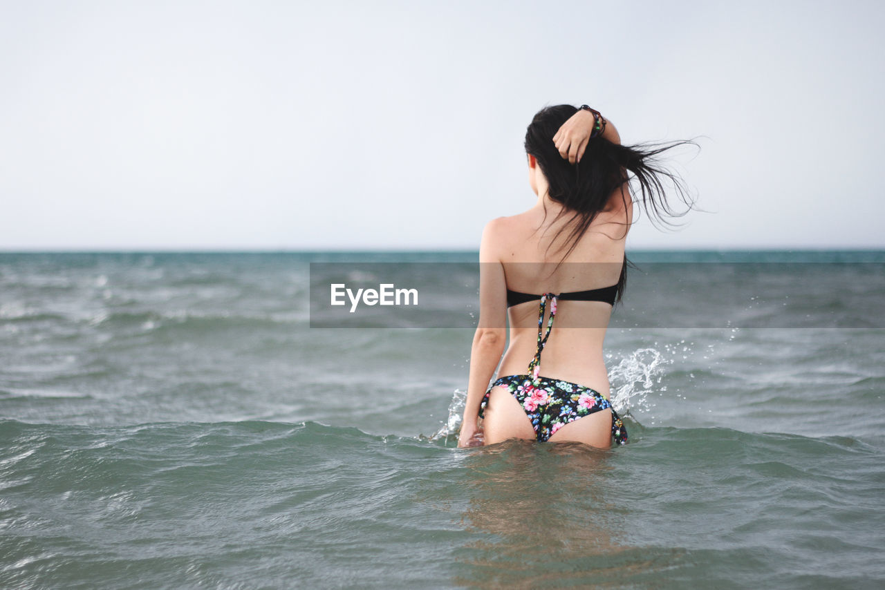 WOMAN STANDING ON BEACH