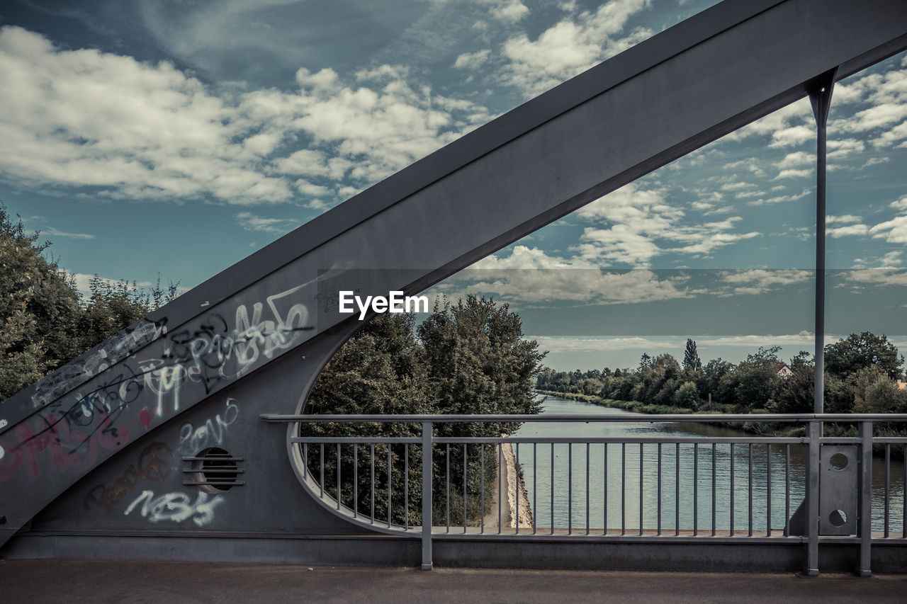 Close-up of railing by bridge against sky