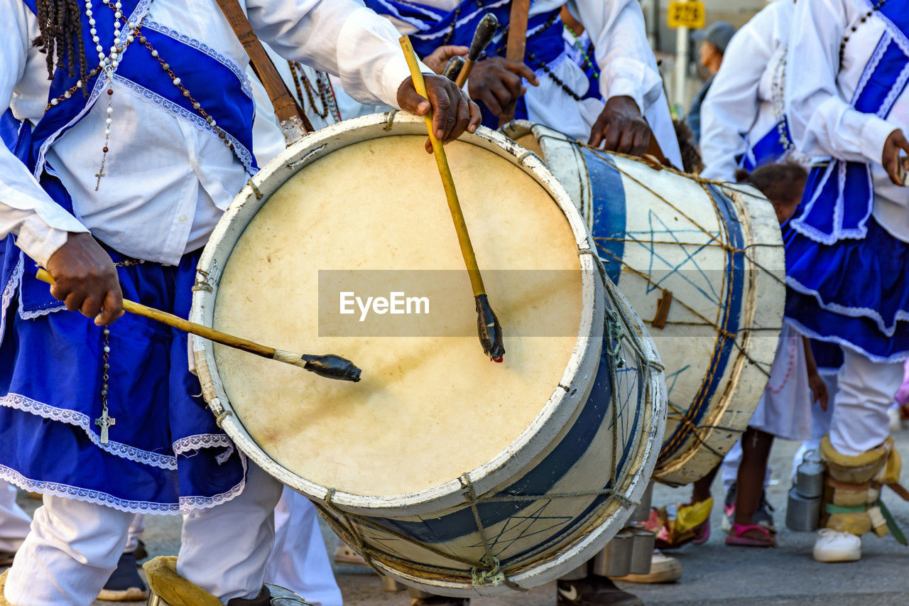 midsection of people playing drum