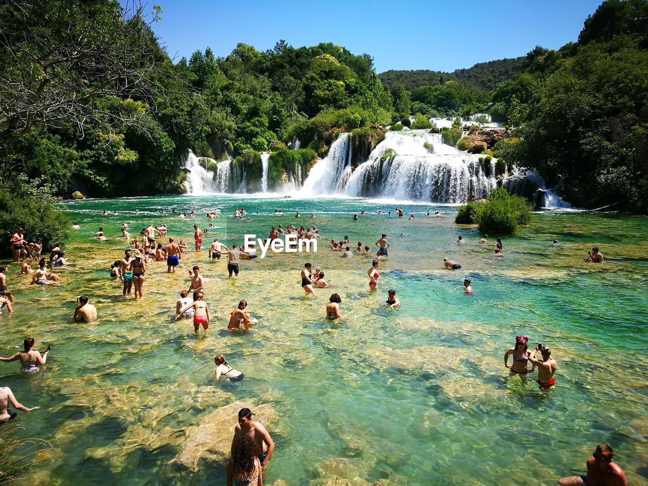 PEOPLE SWIMMING IN WATER AT PARK